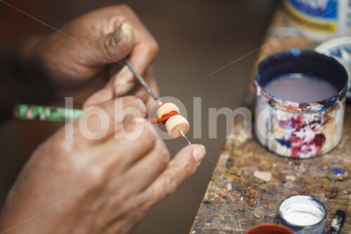 Glasieren eines Keramik-Rohlings (Peru, Manos Amigas) - lobOlmo Fair-Trade-Fotoarchiv