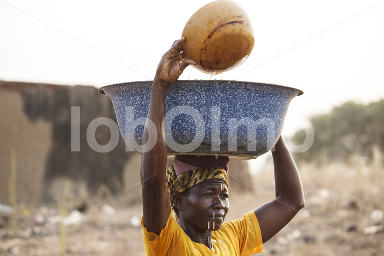 Korbflechterin beim Wasser holen (Ghana, TradeAID) - lobOlmo Fair-Trade-Fotoarchiv