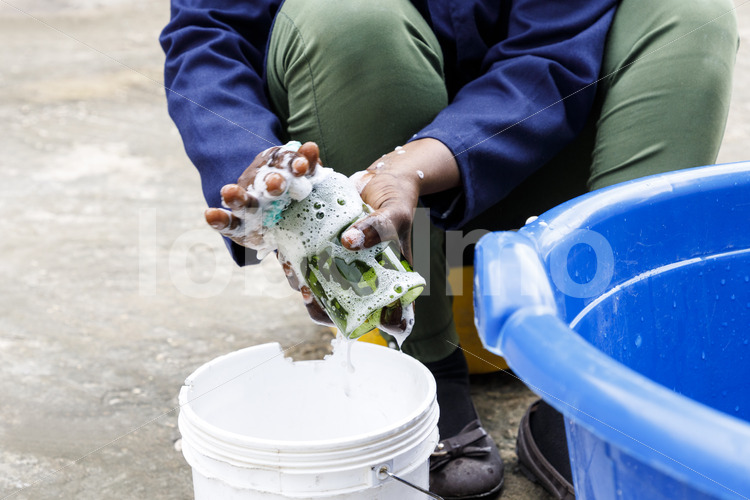 Reinigen eines Upcycling-Trinkglases (Tansania, CHAKO) - lobOlmo Fair-Trade-Fotoarchiv