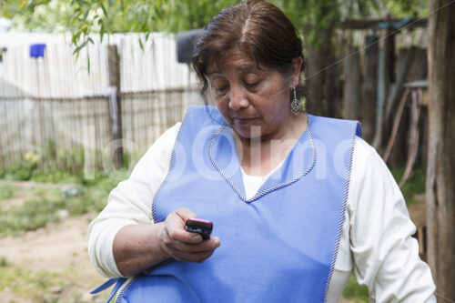 Weberin beim Telefonieren (Chile, Chol-Chol) - lobOlmo Fair-Trade-Fotoarchiv