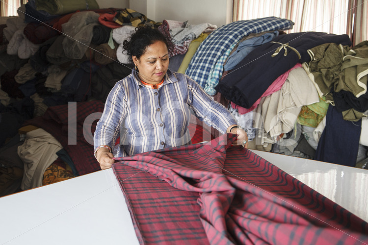 Zuschneiden des Stoffs (Nepal, Mahaguthi) - lobOlmo Fair-Trade-Fotoarchiv